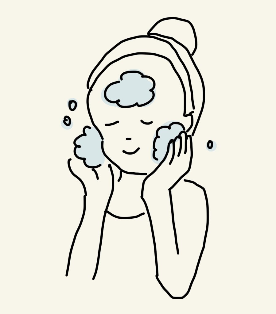 前髪が落ちてこないようにヘアバンドをまいた女性が泡洗顔をしているところ。